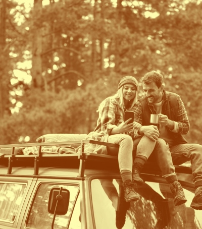 a couple sitting on the roof of a vehicle
