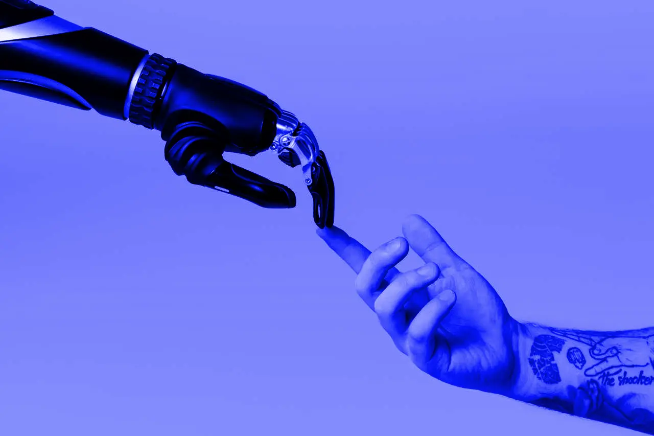 A robotic hand shaking a human hand on a blue background