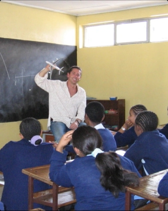Geoff Hucker, founder of Work for Impact, speaking to children at a school