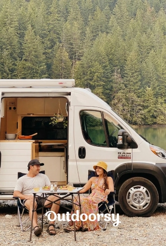 Couple relaxing beside a camper van