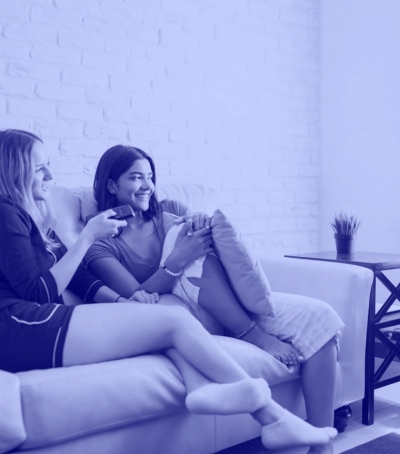 two women sitting on the sofa watching tv