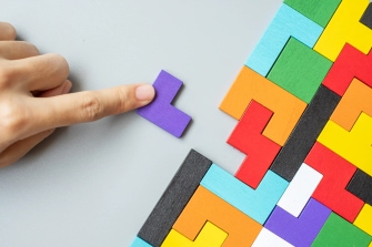 Hand placing a puzzle piece into a structured system representing operational integration